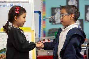 Two young children holding hands