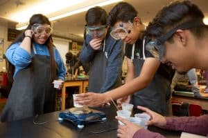 Four Students Doing a Science Experiement