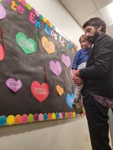 Parent with a child looks at a bulletin board