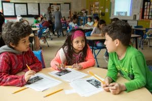 Fourth graders work together to plan life for their “colony” during a class activity focused on colonial America.