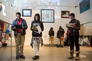 Three high school students look at art