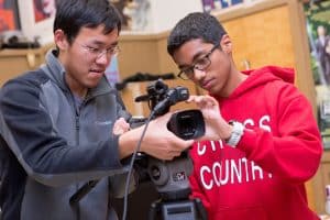 Students in a digital filmmaking class set up the camera in the school studio.