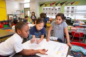 Students in a combined fourth- and fifth-grade class work together on a poster about the Lunar New Year. 