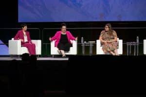 4 person panel sitting on stage speaking