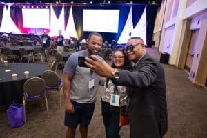 People reconnecting with a selfie at Aurora Symposium