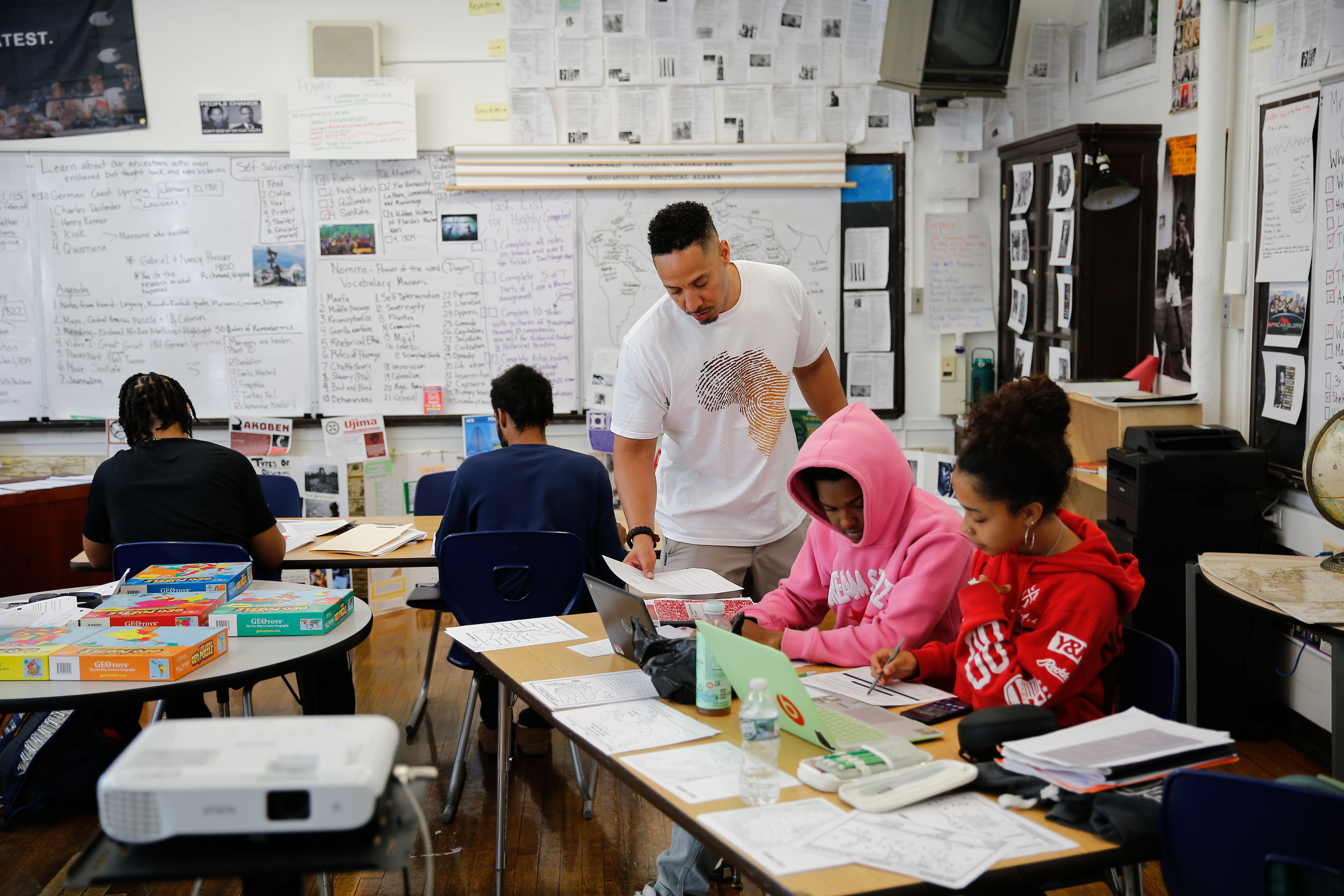 Teacher assisting students working collaboratively at a classroom table