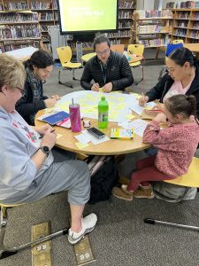 Educators and a young student at a table in the library