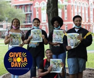 Give Nola Day Event, students hold up flyers