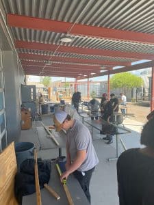 Students working with wood in an open air shop as part of work-based learning