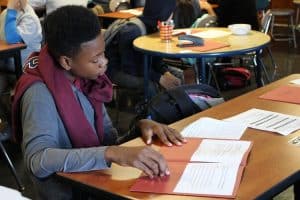 Student reading papers at desk