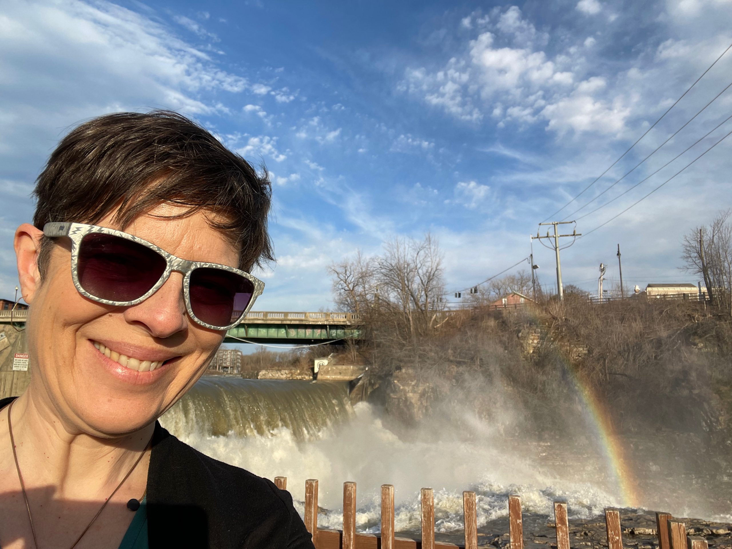 Author Laurie Gagnon by Winooski Falls with a rainbow