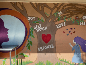 Affirming mural of a tree with Joy, Self Worth, Love and Empower at NVGA