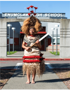 Student wearing clothes representing their cultural heritage in front of Enumclaw High School 