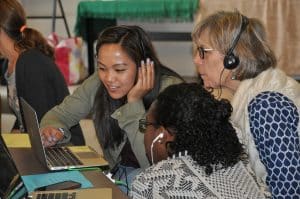 Teacher and students working together on a computer. 