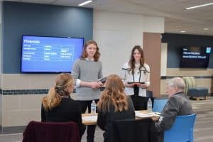 Spring Lake Park High School pathways students presenting a Sharktank-style pitch for an adult panel.