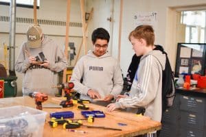 Students at Spring Lake High School collaborating on a project in a wood-shop.