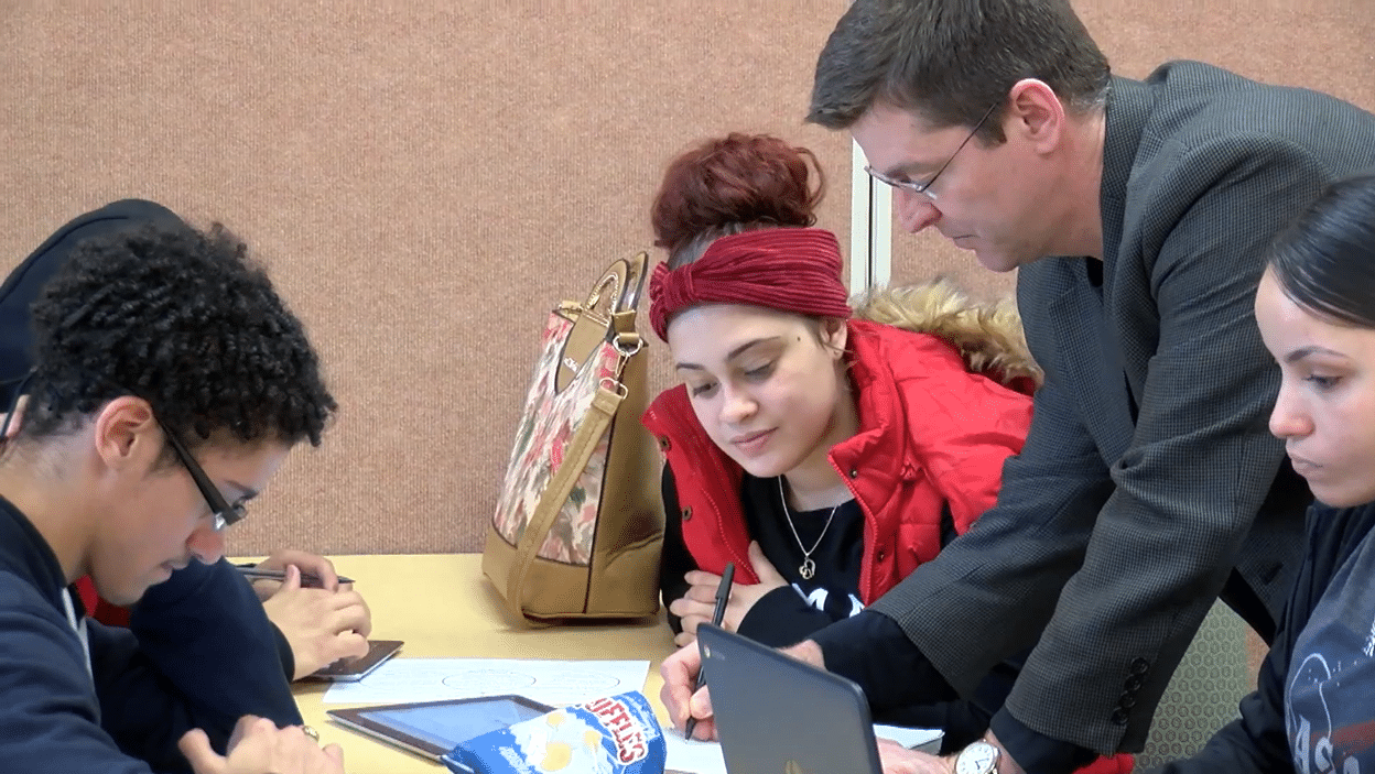 Teacher Helping a Student at a Table