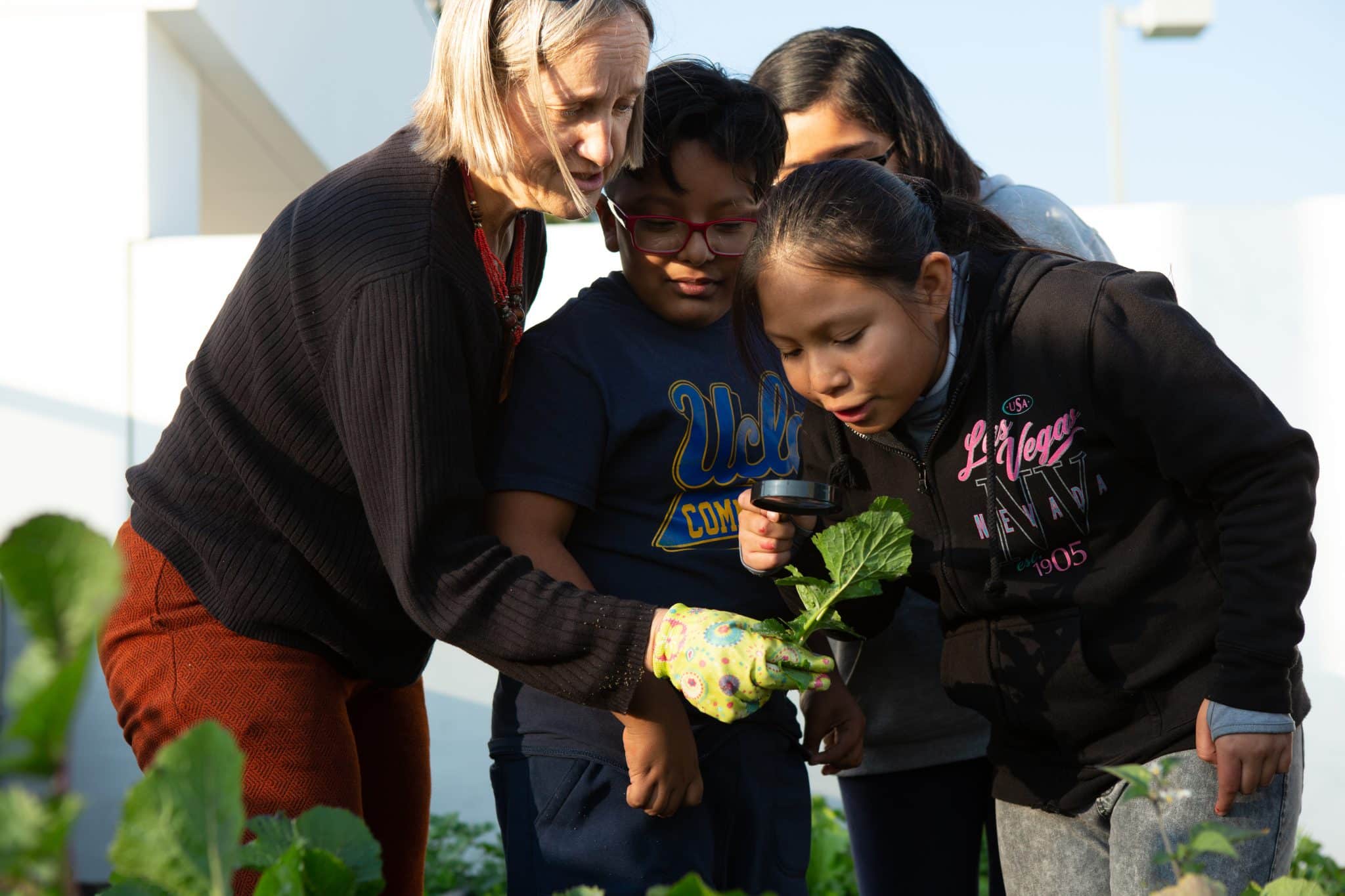 Teacher and Students Outdoors Looking at a Leaf