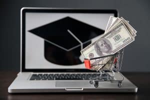 Shopping cart of money in front of graduation cap to signify education funding. 