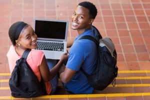 happy young african college couple with laptop computer