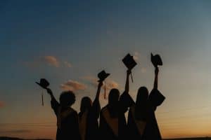 Students graduating in sunset. 