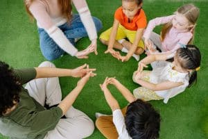 Two teachers and four students sit in a circle