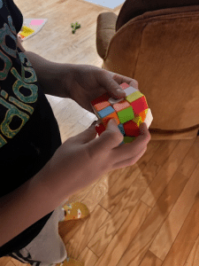 Young child working on solving a rubric cube. 